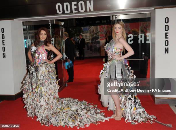 Two women wearing paper dresses pose at the Royal Film Performance 2011 of Hugo at the Odeon Cinema in Leicester Square, London.