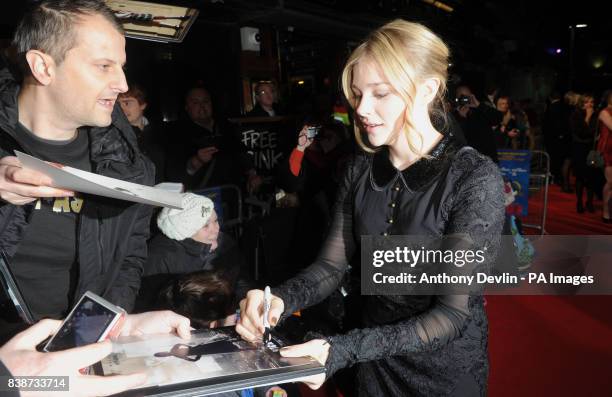 Chloe Moretz signs autographs as she arrives for the Royal Film Performance 2011 of Hugo at the Odeon Cinema in Leicester Square, London.