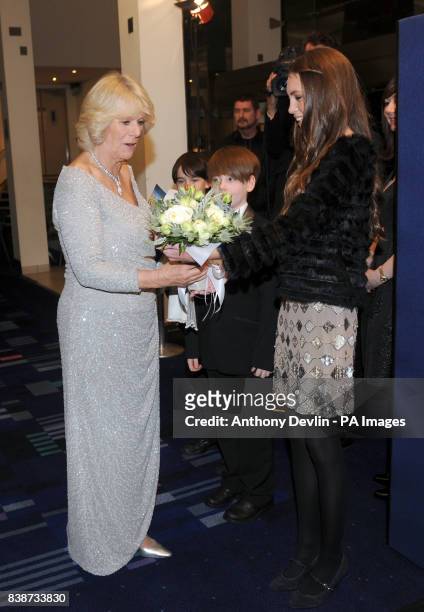 Duchess of Cornwall is presented with flowers by Samantha King as she and the The Prince of Wales attend attend the Royal Film Performance 2011 of...