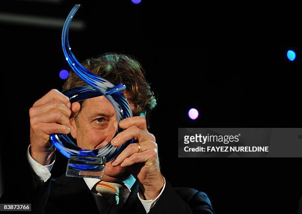 German goalkeeper Harald Schumacher looks through his special award on December 1, 2008 during an ceremony organized by the Algerian sport newspaper...