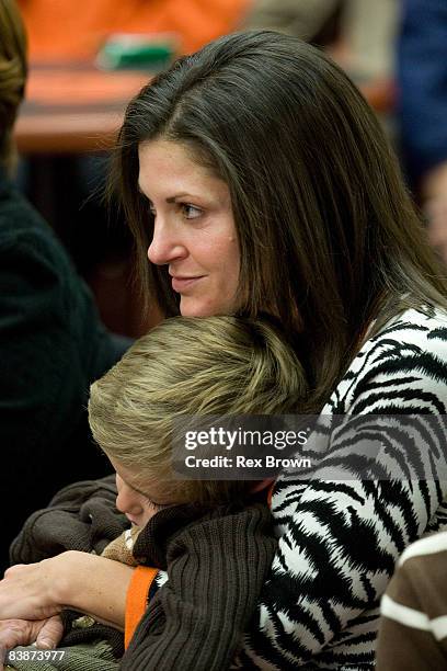 Kathleen Swinney, wife of new head coach Dabo Swinney of the Clemson Tigers, hold there son Clay during a press conference at Memorial Stadium on...