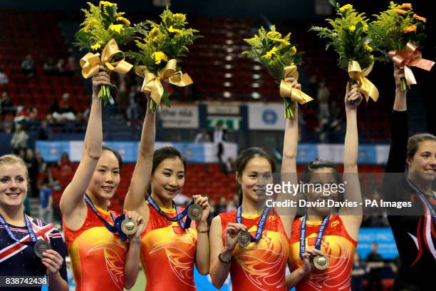 China's women's team of He Wenna, Huang Shanshan, Li Dan, Zhong Xingping celebrate with their gold medals after winning the individual trampoline...