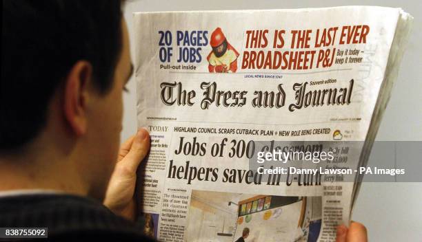The last broadsheet format publication of the Press and Journal newspaper is read by an unnamed man in Glasgow.