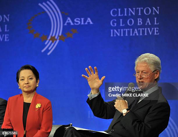 Philippine President Gloria Arroyo looks on while former US president Bill Clinton speaks at the Clinton Global Initiative in Hong Kong on December...