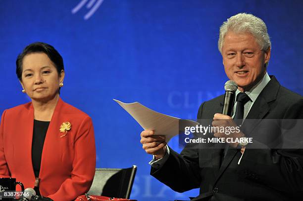 Philippine President Gloria Arroyo looks on while former US president Bill Clinton speaks at the Clinton Global Initiative in Hong Kong on December...