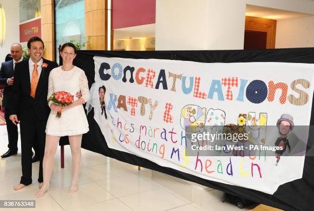 Barefooted Katrina Scaife and Andrew Ford see the sign that was made for them after their wedding ceremony while they are running in the 31st Virgin...