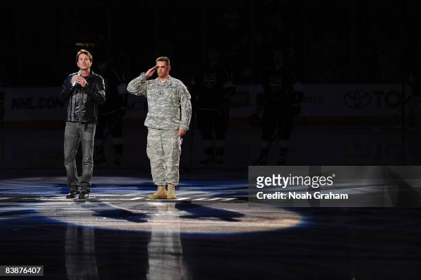 Singer Davis Gaines sings the National Anthem with military hero U.S. Army Sergeant First Class Douglas Dietal prior to the game between the Toronto...