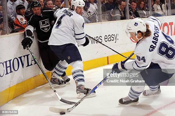 Jeff Finger and Mikhail Grabovski of the Toronto Maple Leafs battle for the puck alongside the boards against Kyle Calder of the Los Angeles Kings...