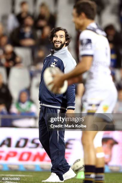 Injured Cowboys player Johnathan Thurston shares a laugh with a team mate before the round 25 NRL match between the Wests Tigers and the North...