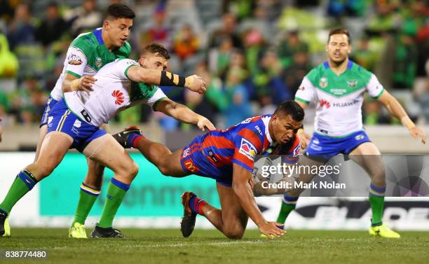 Jacob Saifiti of the Knights is tackled during the round 25 NRL match between the Canberra Raiders and the Newcastle Knights at GIO Stadium on August...