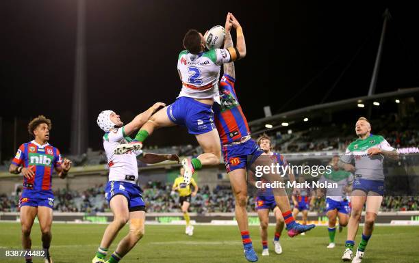 Nikola Cotric of the Raiders and Shaun Kenny-Dowall of the Knights contest a high ball during the round 25 NRL match between the Canberra Raiders and...