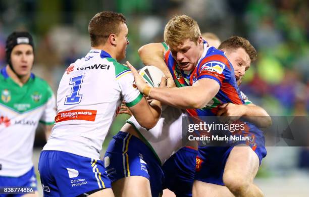 Joshua King of the Knights is tackled during the round 25 NRL match between the Canberra Raiders and the Newcastle Knights at GIO Stadium on August...