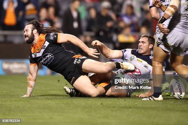 Aaron Woods of the Tigers celebrates scoring a try during the round 25 NRL match between the Wests Tigers and the North Queensland Cowboys at...