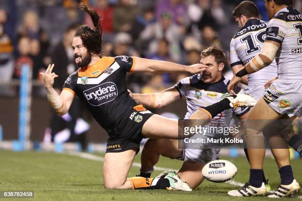 Aaron Woods of the Tigers celebrates scoring a try during the round 25 NRL match between the Wests Tigers and the North Queensland Cowboys at...