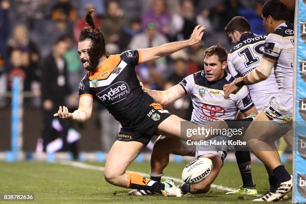 Aaron Woods of the Tigers celebrates scoring a try during the round 25 NRL match between the Wests Tigers and the North Queensland Cowboys at...