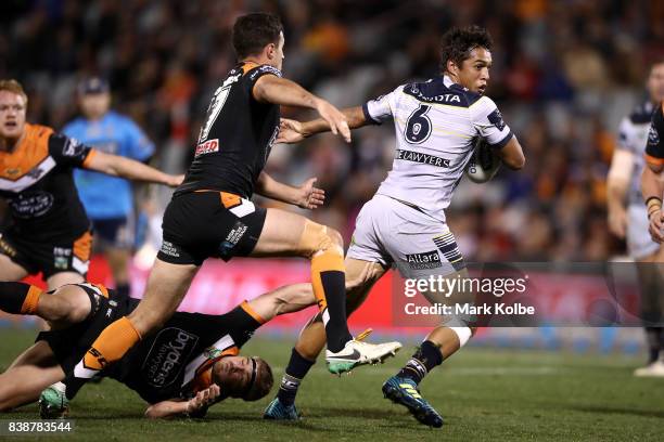 Te Maire Martin of the Cowboys is tackled during the round 25 NRL match between the Wests Tigers and the North Queensland Cowboys at Campbelltown...