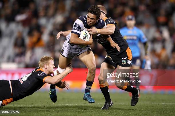 Te Maire Martin of the Cowboys is tackled during the round 25 NRL match between the Wests Tigers and the North Queensland Cowboys at Campbelltown...
