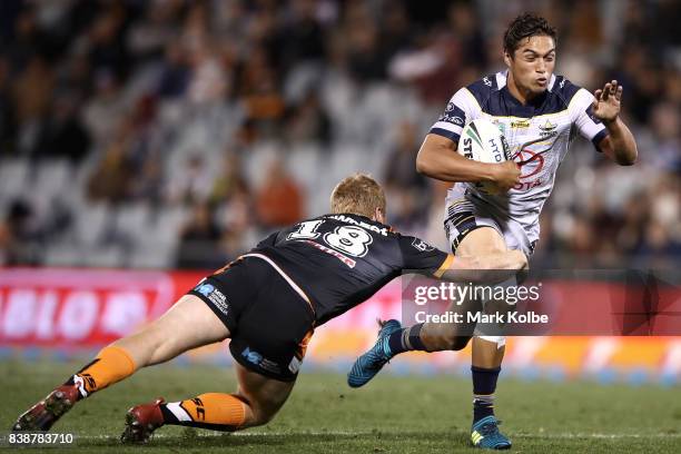 Te Maire Martin of the Cowboys is tackled during the round 25 NRL match between the Wests Tigers and the North Queensland Cowboys at Campbelltown...