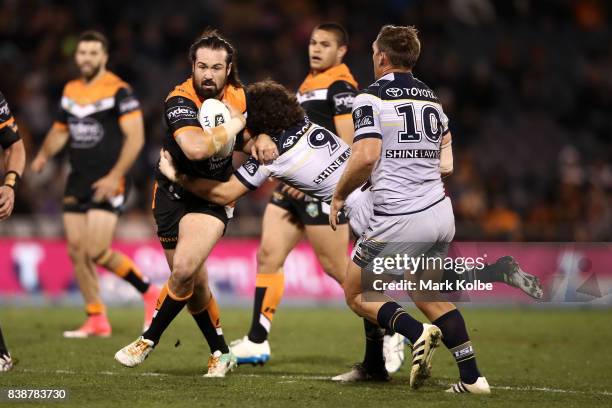 Aaron Woods of the Tigers is tackled during the round 25 NRL match between the Wests Tigers and the North Queensland Cowboys at Campbelltown Sports...