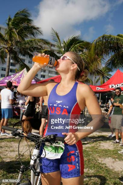Cyclist having a drink at the Publix Family Fitness Weekend event at Lummus Park.