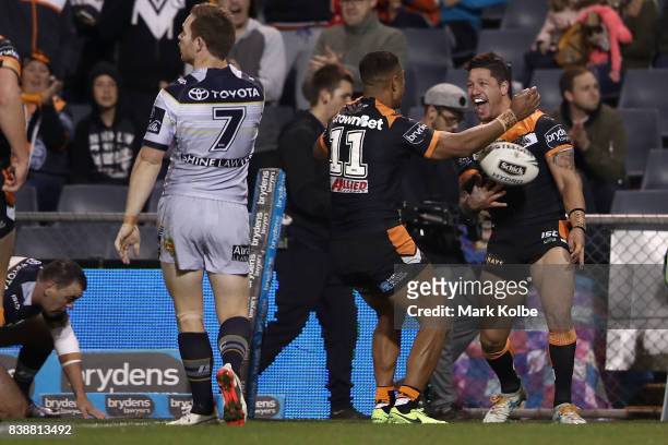 Malakai Watene-Zelezniak of the Tigers celebrates with his team mates after scoring a try during the round 25 NRL match between the Wests Tigers and...