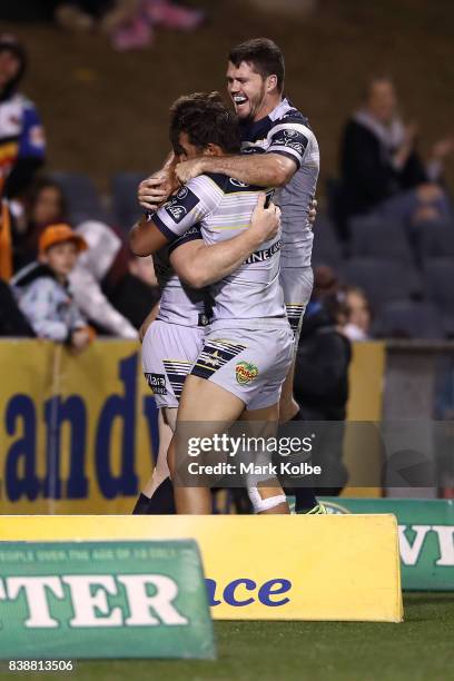 Michael Morgan, Te Maire Martin and Lachlan Coote of the Cowboys celebrate Morgan scoring a try during the round 25 NRL match between the Wests...