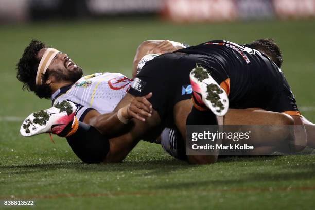 Javid Bowen of the Cowboys grimaces after a tackle during the round 25 NRL match between the Wests Tigers and the North Queensland Cowboys at...