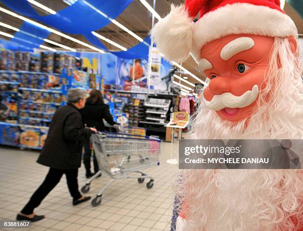 Customer walks past a Santa Claus doll as he shops in a supermarket, on December 2, 2008 in Rots, west of France days before the end of the Year's...