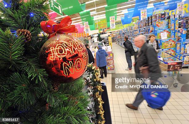 Customer walks past Christmas decorations as he shops in a supermarket, on December 2, 2008 in Rots, west of France days before the end of the Year's...