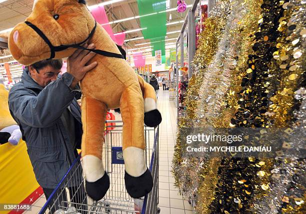 Customer buys a stuffed horse as he shops in a supermarket, on December 2, 2008 in Rots, west of France days before the end of the Year's...