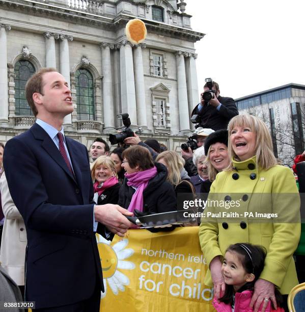 Prince William flips a pancake during a Northern Ireland Cancer Fund for Children event outside Belfast City Hall, during his and Kate Middleton's...