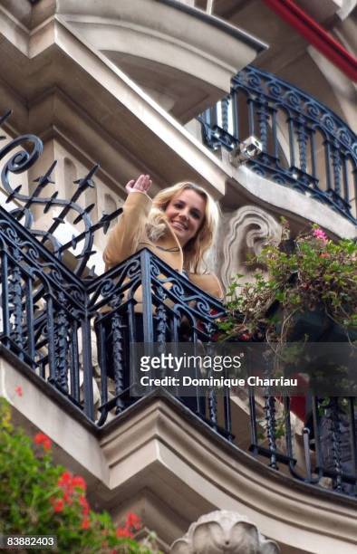 Singer Britney Spears waves to her fans from the balcony of the Plaza Athenee Hotel on November 28, 2008 in Paris, France.