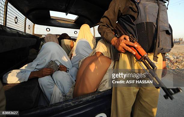 Pakistani paramilitary soldier guards suspected arrest criminals during a search operation at an Afghan refugee camp in Karachi on December 2, 2008....