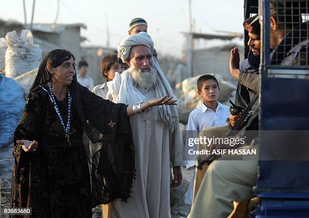 An Afghan refugee woman resist with troops after the arrest of one of his relative during a search operation in Karachi on December 2, 2008....