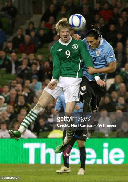 Uruguay's Martin Caceres and Republic of Ireland's Andrew Keogh battle for the ball.