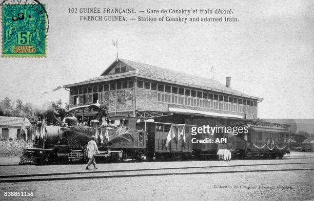 Carte postale illustrée par la photographie de la gare de Conakry et d'un train décoré en Guinée française.