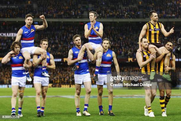 Matthew Boyd and Robert Murphy of the Bulldogs get carried off with Luke Hodge of the Hawks for their retirement match during round 23 AFL match...