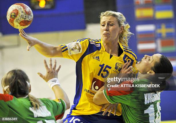 Sweden's Johanna Ahlm passes the ball between Belorussians Iryna Dronova and Alesia Kurchankova during their group C match in the preliminary round...