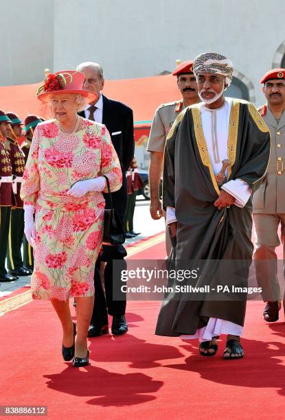 Queen Elizabeth II walks towards her plane with the Sultan of Oman, His Majesty Sultan Qaboos bin Said, before she and the Duke of Edinburgh depart...