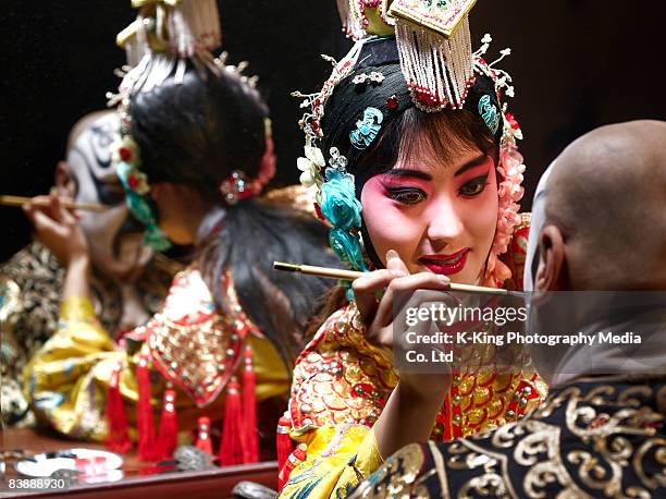 chinese opera singer applying makeup to male - peking opera stock pictures, royalty-free photos & images