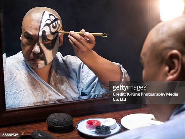 mann auftragen von make-up für die chinesische oper - schauspieler stock-fotos und bilder