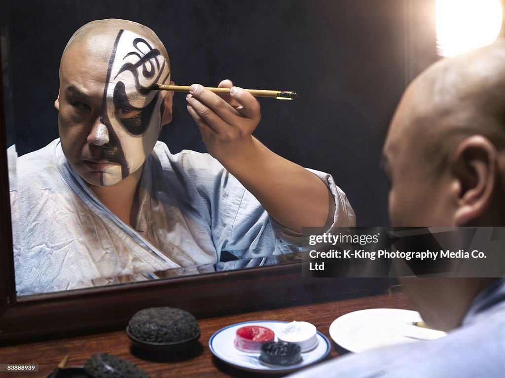Man applying makeup for Chinese Opera