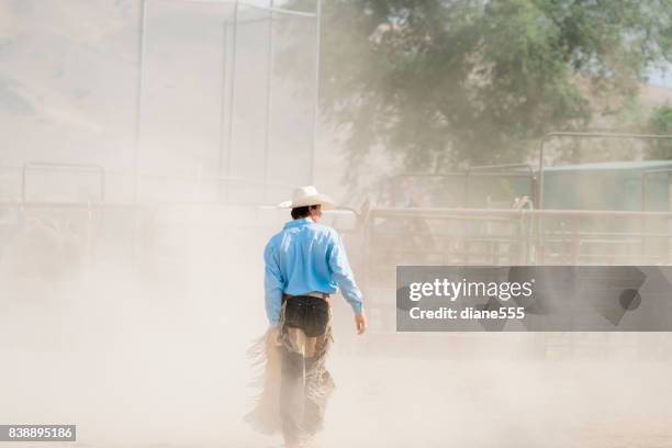 bull rider walks through the dust after his ride - bull riding stock pictures, royalty-free photos & images