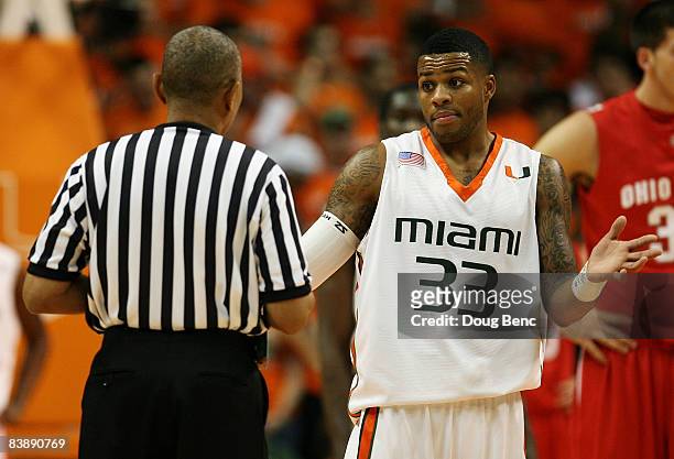 Jack McClinton of the Miami Hurricanes talks with referee Tony Greene as the other officials watch a replay while taking on the Ohio State Buckeyes...