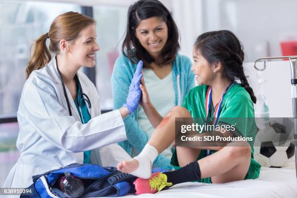 il medico del pronto soccorso dà al giovane paziente un alto cinque - medical examination of young foto e immagini stock