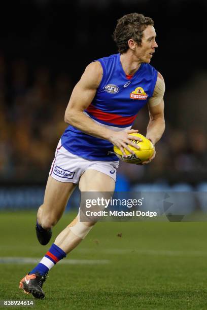 Robert Murphy of the Bulldogs runs with the ball during round 23 AFL match between the Hawthorn Hawks and the Western Bulldogs at Etihad Stadium on...