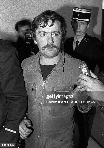 Picture taken on November 5, 1985 shows Bernard Laroche, flanked by two French gendarmes, arriving at the Epinal court house, eastern France. A...