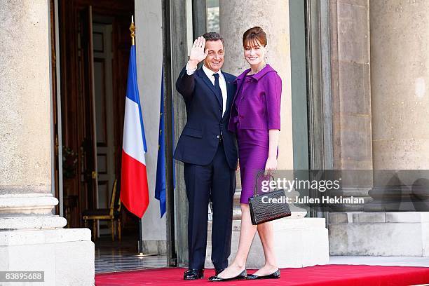 French President Nicolas Sarkozy and his wife Carla Bruni-Sarkozy arrive in the courtyard of the Elysee for the garden party following the Bastille...