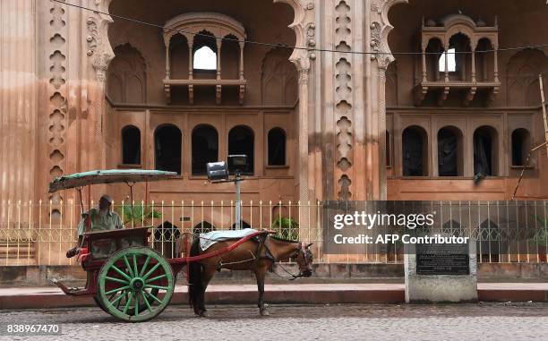 An Indian horse cart owner waits for passangers outside the Bara Imambara, a colossal imambara in Lucknow, northern India, on August 25, 2017. / AFP...