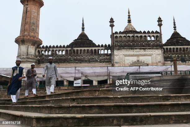 People walk down stairs next to the mosque at the Bara Imambara, a colossal imambara complex in Lucknow, northern India, on August 25, 2017. / AFP...